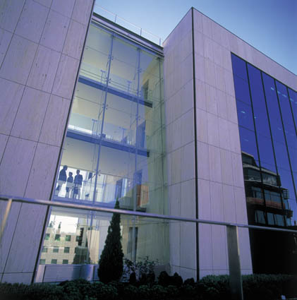 Vista desde abajo de la fachada de un edificio moderno acristalado