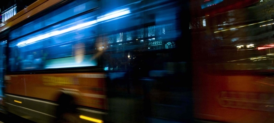 Movilidad urbana sostenible, fomento del Transporte público. Vista de un autobús urbano circulando por la noche