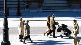 Vista frontal de la parte inferior de un edificio colonial con unos peatones paseando