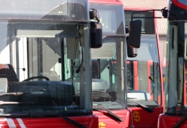 Vista frontal de una línea de aparcamiento de autobuses urbanos colocados en dos filas enfrentadas