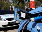 Detalle de enchufe de recarga conectado a vehículo eléctrico