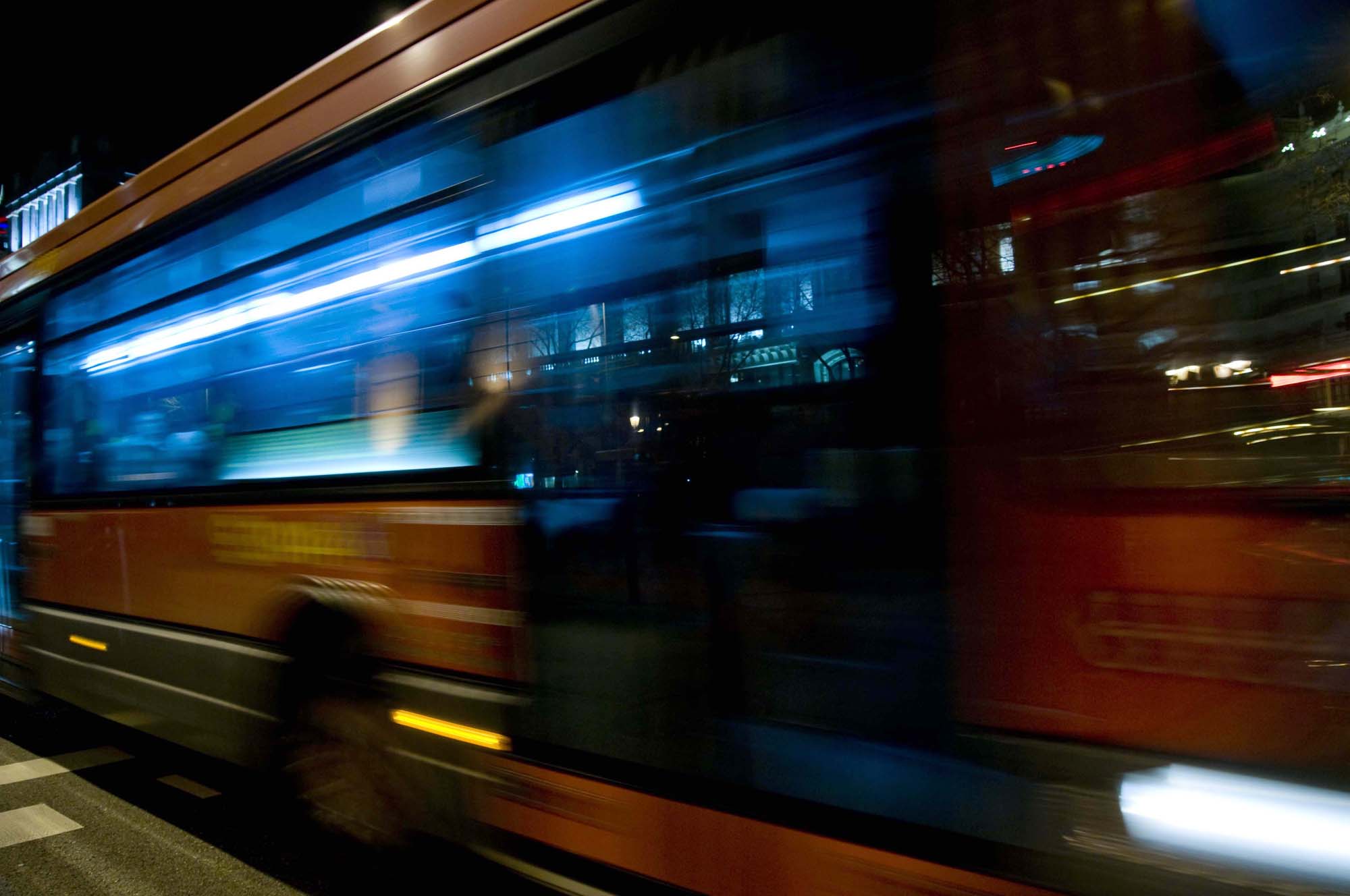 Movilidad urbana sostenible, fomento del Transporte público. Vista de un autobús urbano circulando por la noche