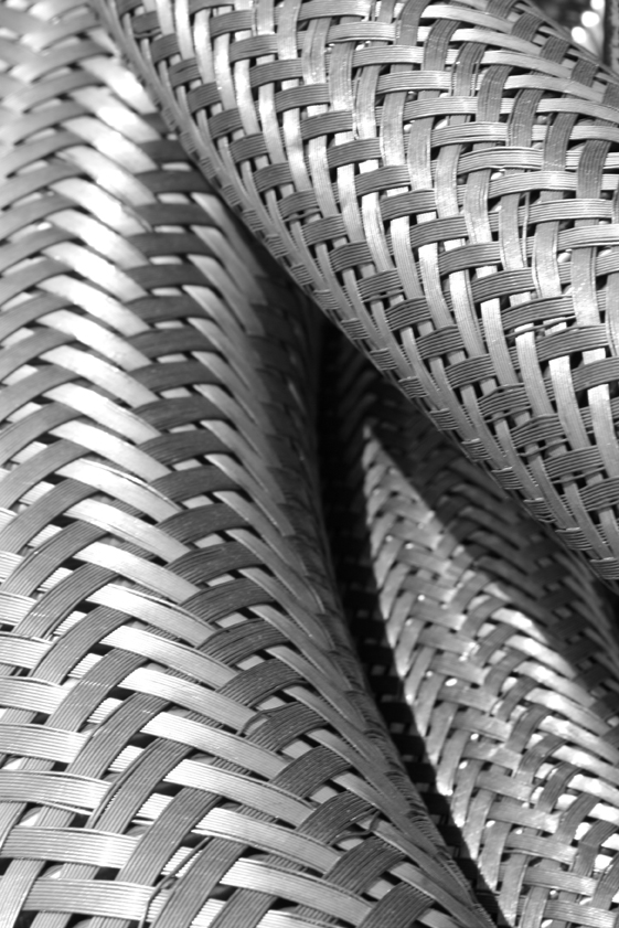 Transformación de la enegía. Vista frontal en primer plano de unos cables de entrelazado metálico plateados