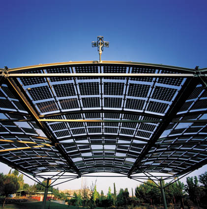 Vista desde abajo de una pérgola solar fotovoltaica sobre un cielo azul 