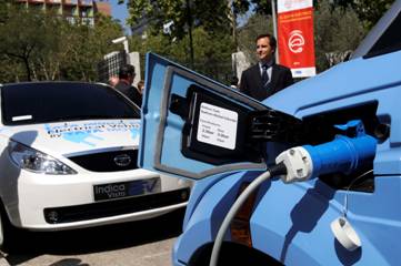 Detalle de enchufe de recarga conectado a vehículo eléctrico