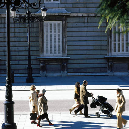Vista frontal de la parte inferior de un edificio colonial con unos peatones paseando