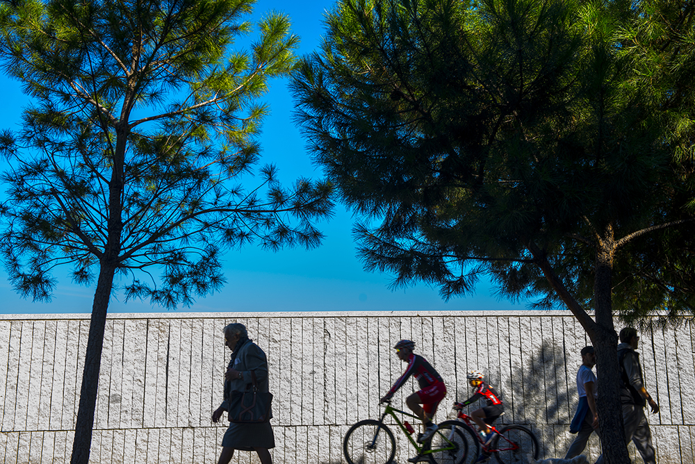 Peatones junto a un carril bici por el que circula un ciclista