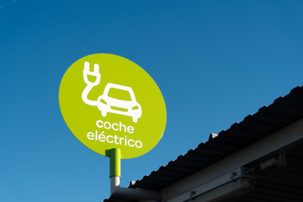 Primer plano del distintivo de punto de recarga de vehículo eléctrico señalizado en un aparcamiento